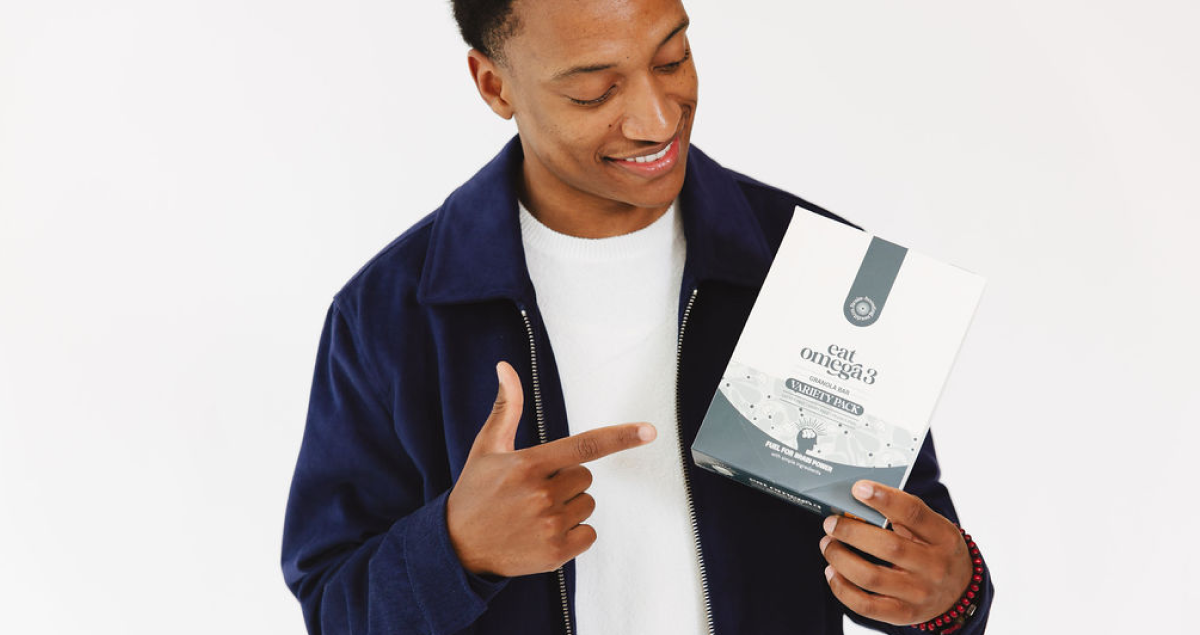 Founder Bright Djampa holding the variety box of granola bars from Omega 3.